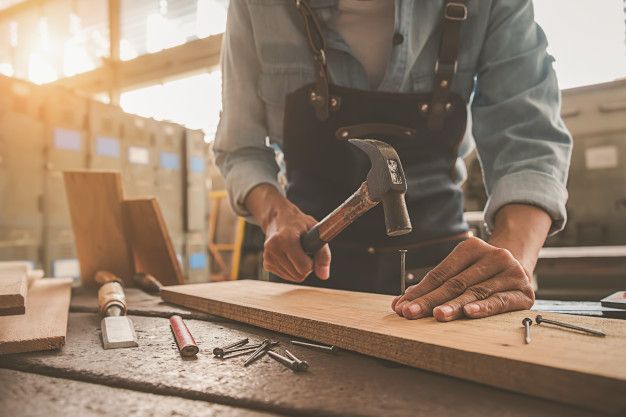 carpenter working with equipment on wooden table in carpentry shop premium photo